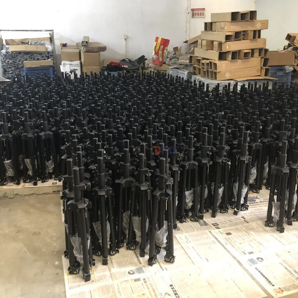 Rows of black TV stand bases stored in a warehouse.