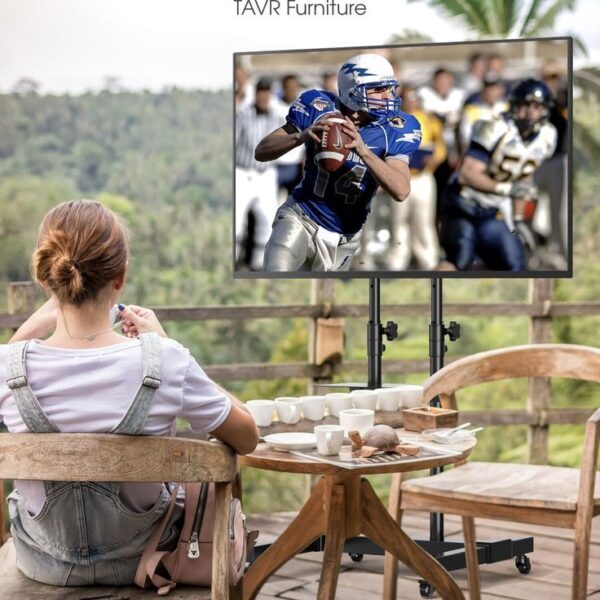 Person enjoying a football game on a large screen outdoors.