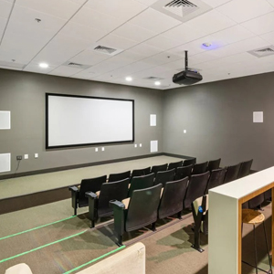 Hospital conference room with a ceiling-mounted projector and a screen.