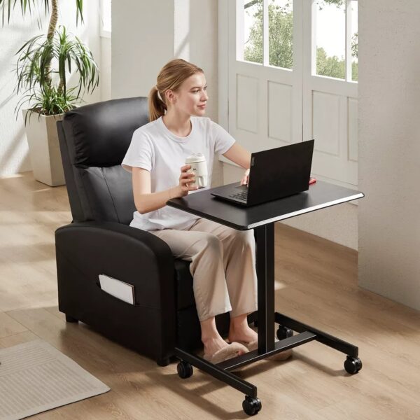 Woman working on a laptop while seated in a recliner with a mobile desk.