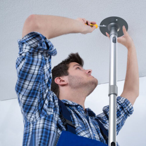 A technician attaching a ceiling mount for a projector.