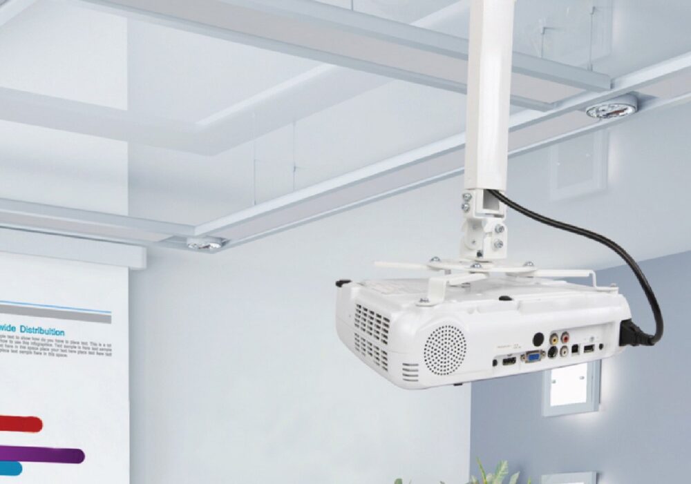 A ceiling-mounted projector in a modern, well-lit room with a projection screen.